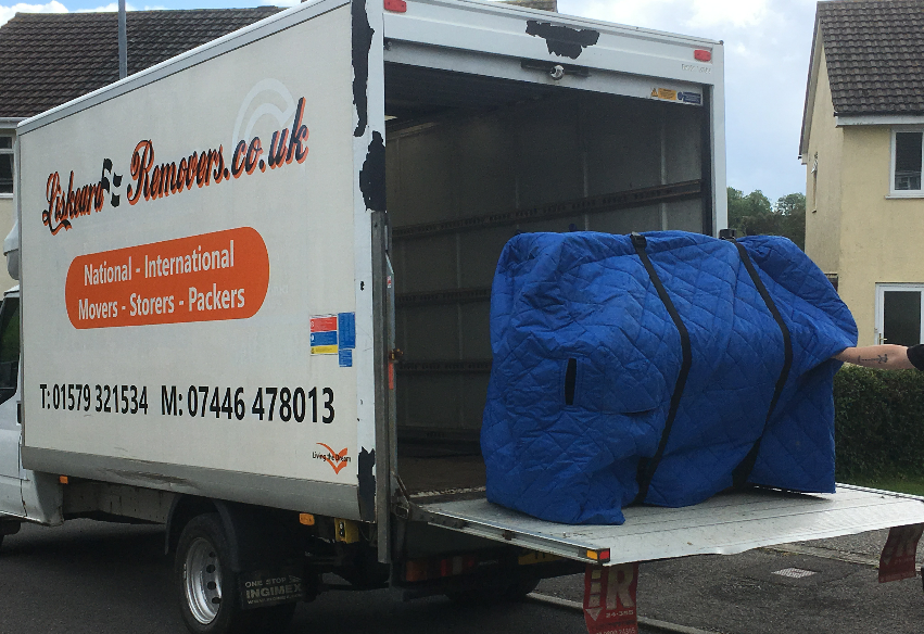An Image of a wrapped piano being tail-lifted off a removals van